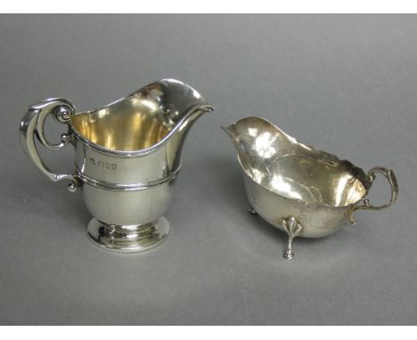 A Victorian silver helmet-shaped milk jug with scroll handle, &amp; on round pedestal foot, 4” high, London 1894, by Gibson &