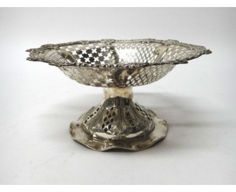 A late Victorian silver tazza, of shaped circular form, having pierced decoration within a cast floral border, raised on a pi