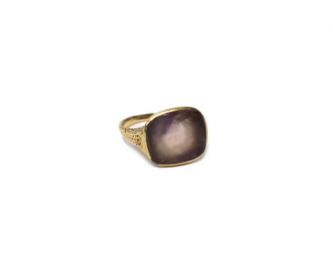 A gold ring mounted with a cushion shaped pale amethyst, the shoulders with floral engraved decoration, possibly last quarter
