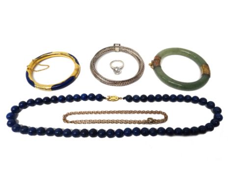 A single row necklace of lapis lazuli beads, on a silver gilt clasp, a gilt metal mounted lapis lazuli bangle, a reconstitute