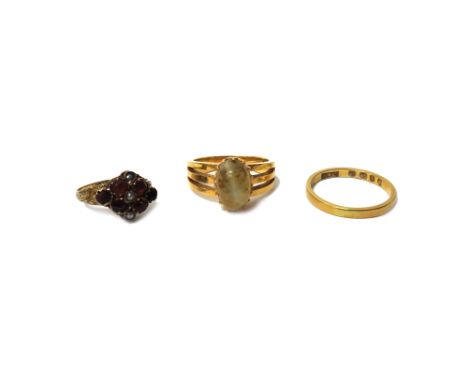 A gold ring mounted with an oval chrysoberyl cat's eye, ring size J and a half, a 9ct gold, seed pearl and red gem set cluste