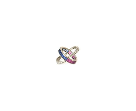 A ruby, sapphire and diamond swingover and under night and day eternity ring, the principal band mounted with baguette rubies