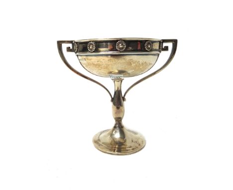 A silver twin handled bowl, the rim decorated with flowerhead shaped motifs, between angular handles, raised on a circular tr