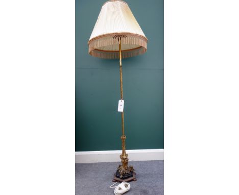 An Edwardian Gothic inspired brass and marble mounted standard lamp, raised on a hexagonal base, with a pleated silk shade.