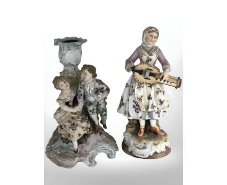 A German Volkstedt figural porcelain candlestick and a further depicting a lady playing a hurdy-gurdy, tallest 18.5 cm.