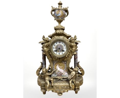 A 19th century French Louis XVI style gilt metal mantel clock, the ornate case decorated with Sevres-style porcelain panels d