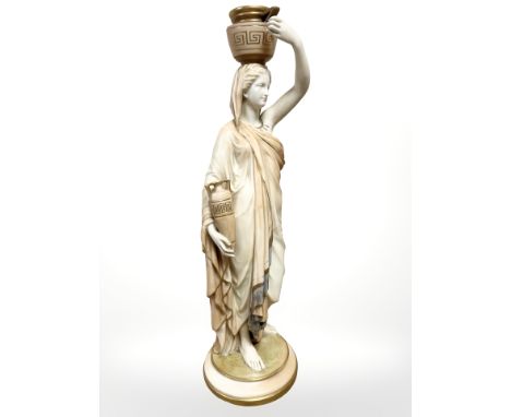 A Royal Worcester blush ivory figure of a Grecian female water carrier, her left arm raised up towards the water vessel which