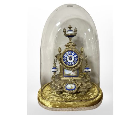 A 19th century French gilt metal porcelain and enamel mantel clock, with pendulum and key, upon a gold velvet oval plinth wit