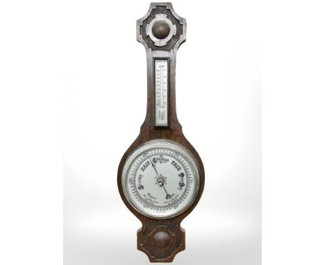 An early 20th century carved oak barometer with silvered dial, length 76 cm.