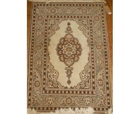 A Tabriz style cream ground carpet, having a foliate quartered field, multi-bordered and fringed L.134cm W.92cm