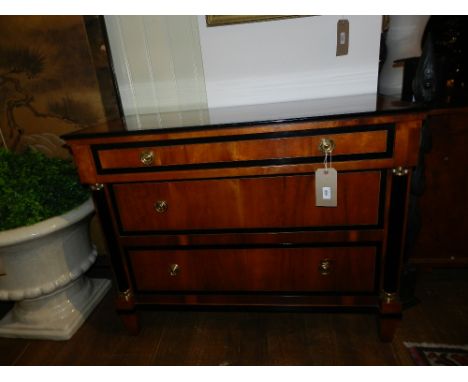 A Beidermier style satin beech wood and parcel ebonised commode, fitted three graduated long drawers, flanked by split half p