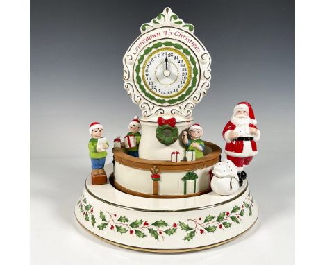 Porcelain rotating centerpiece featuring Santa, his elves, and gifts, with festive motifs and a beautiful large clock on top 