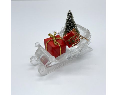 Part of the Exquisite Accents collection. Includes a clear crystal Santa sleigh with two wrapped gifts and a small pine tree.