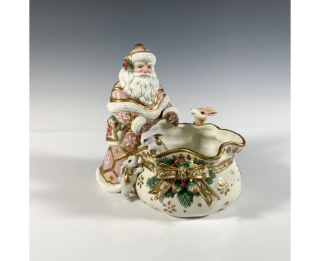 Santa Claus in a pink robe holding a sack surrounded by two white bunnies and a small deer. The sack features a large gold gi
