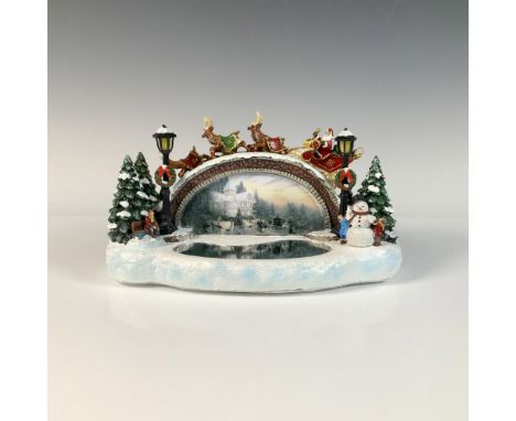Acrylic figurine with glitter, titled, Illuminated Bridge. It features a battery operated light up bridge with Santa and his 