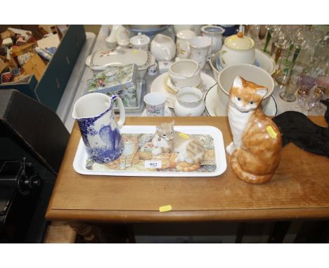 A Babbacombe model of a cat, a blue and white jug, an ornament of a cat and a tray