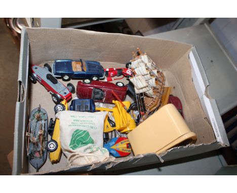 A box containing various die cast toys and a model boat