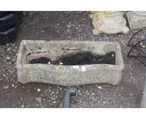 A cast concrete plant trough with bowed front and floral motif