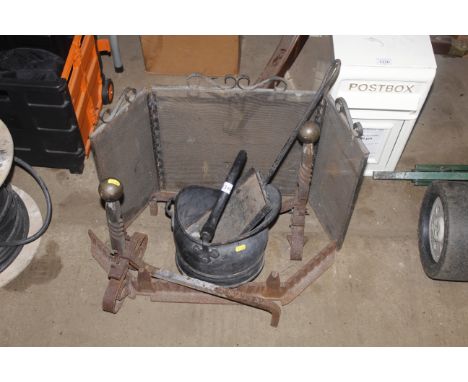 A spark guard, pair of wrought iron fire dogs, coal helmet and a shovel