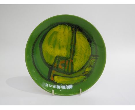 A Poole Pottery Delphis range plate in green glazes with ochre and orange. Marks to base and painters mark for Carol Cutler. 