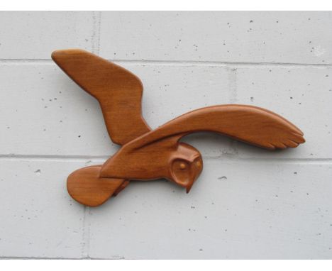 A teak wall hanging of a Barn Owl in flight. Marked 'K' verso. 35cm tall x 59cm wide 