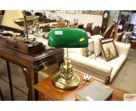 A reproduction brass desk lamp with green shade