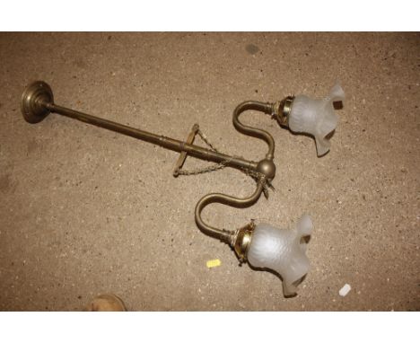A brass hanging light fitting with two frosted glass shades