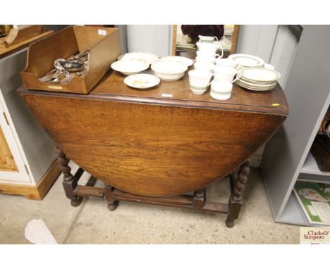 An oak gate leg dining table raised on barley twist supports