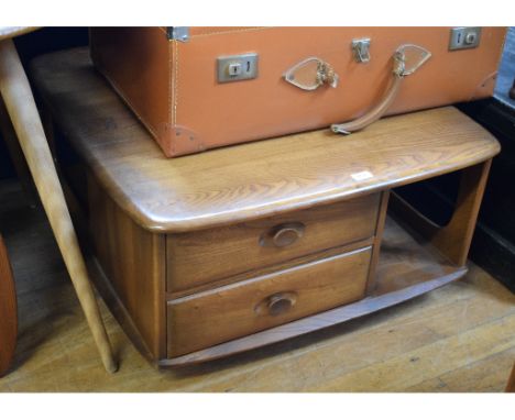 An Ercol elm revolving coffee table, 80 cm wide, an Ercol circular dining table, an Ercol dresser/wall unit, an Ercol sideboa