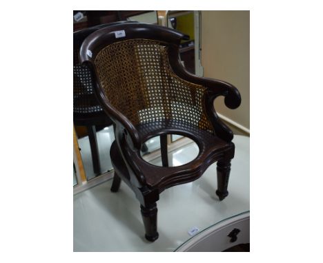 A 19th century child's bergere style commode chair