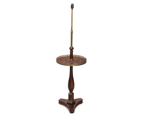 A REGENCY STYLE MAHOGANY AND BRASS STANDARD LAMP early 20th Century, the circular shelf with pierced brass gallery. 133cm hig