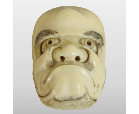 A Japanese carved ivory netsuke, in the form of a Noh mask, 5cm high