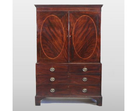 A George III mahogany linen press, the upper section fitted with slides and enclosed by a pair of rosewood banded panelled do