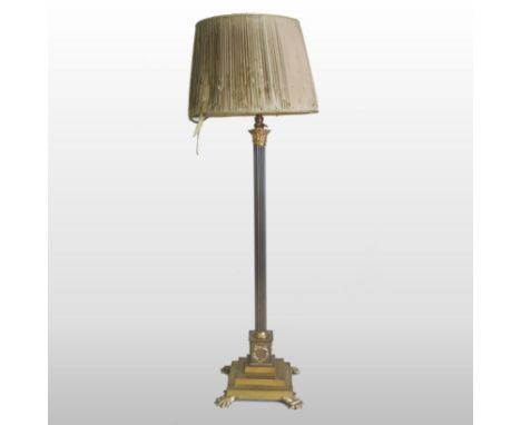 A Victorian brass standard lamp and shade, in the form of a fluted Corinthian column, on paw feet, 160cm high