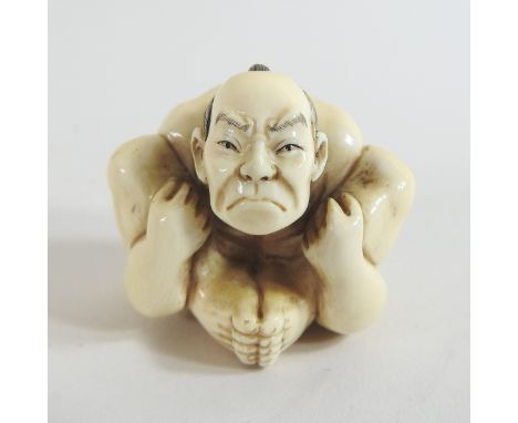 A Japanese carved ivory netsuke, in the form of a contorted wrestler, signed, 3cm high