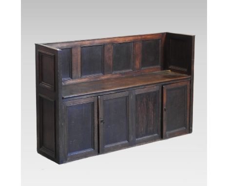 A 19th century oak hall bench, the panelled back above two pairs of panelled cupboard doors, 147cm