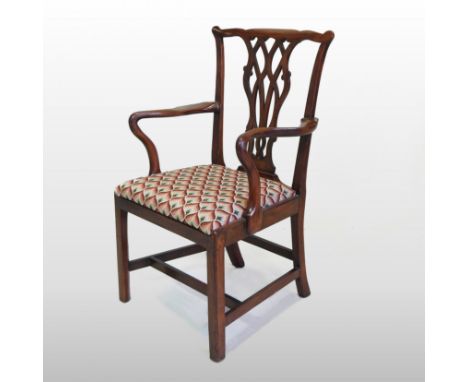 A George III mahogany elbow chair, in the manner of Thomas Chippendale, with ribbon carved splat, shepherd's crook arms and a