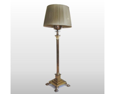A Victorian brass standard lamp and shade, in the form of a fluted Corinthian column, on paw feet, 160cm high