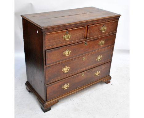 An early 19th century oak and mahogany crossbanded chest of two short and three long drawers raised on ogee bracket feet (af)