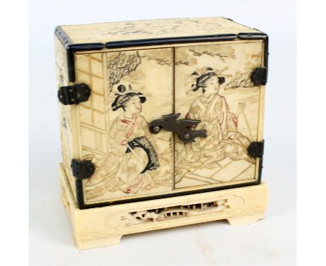 A Japanese Meiji period ivory miniature cabinet overall engraved and inked with figural interior scenes with ebonised edges, 