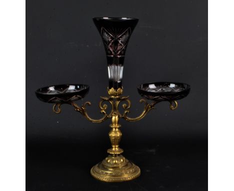 A late 19th century Bohemian cranberry and clear cut glass epergne, the central trumpet flanked by two bowls raised by scroll