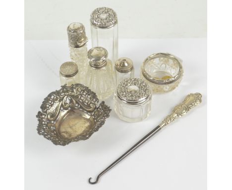 A group of variously hallmarked silver mounted clear glass items to include a hobnail cut cylindrical scent bottle with hinge