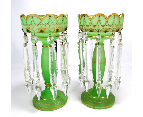 A pair of Victorian green satin glass table lustres with lobed rims and garland and floral motif decorated sides, with ovoid 