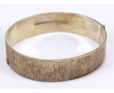 A hallmarked silver textured snap bangle, Birmingham 1974, patent number 1167637.