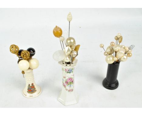 A collection of mainly globular headed hat pins including mother of pearl examples, glass examples, pierced metal filigree ex