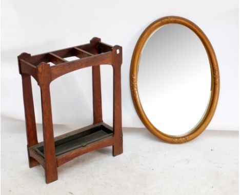 An early 20th century oak three section stick stand, width 55cm, and a modern decorative oval gilt framed mirror (2).