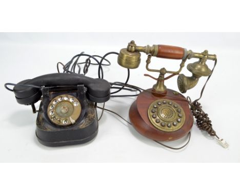 An early 20th century cast iron telephone with enamel spin dial and a 1960s reproduction wooden example (2).