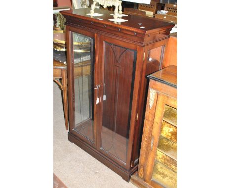 A reproduction mahogany display cabinet, the moulded cornice above a pair of glazed doors, on plinth base with bracket feet.