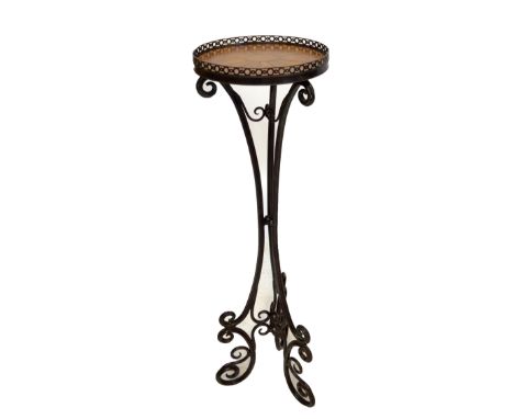 An iron circular jardinière with pressed leather top and scroll decorated tripod base, diameter 31cm, height 108cm.