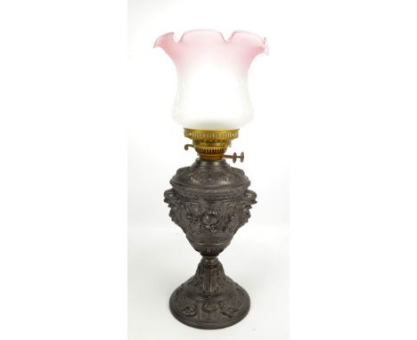 An oil lamp with classical style embossed decoration and shade, height excluding fitment 31cm.